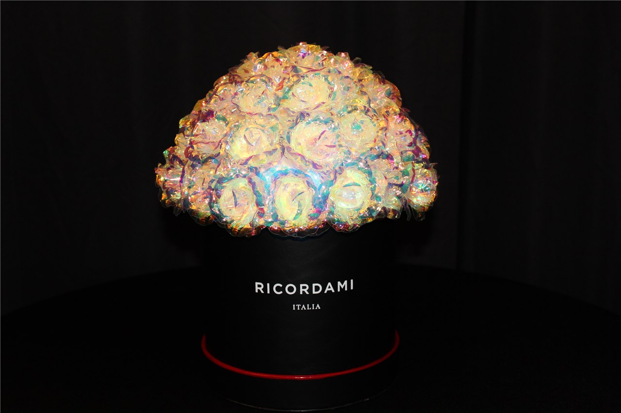 Actual iridescent rose arrangement in a black round container