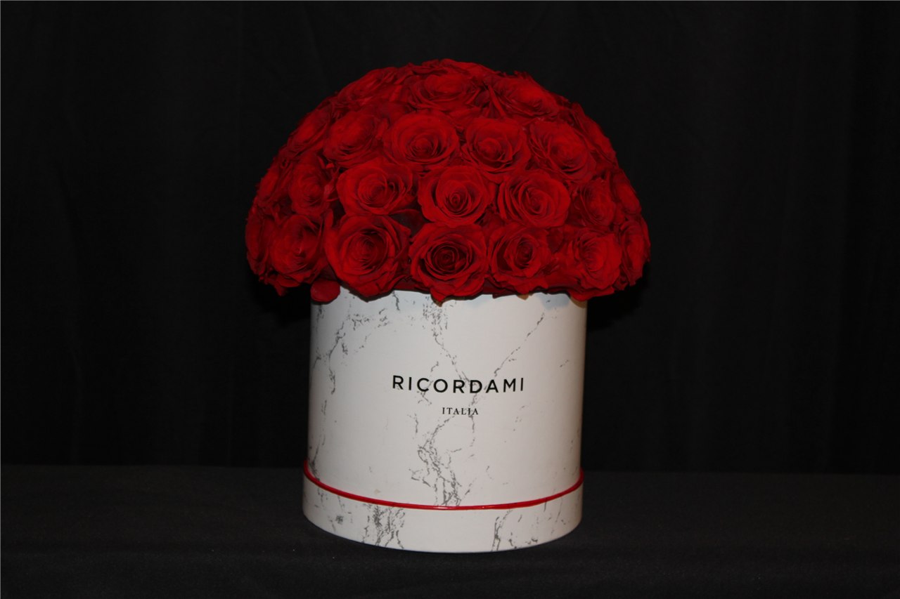 Real red rose arrangement in a white round container